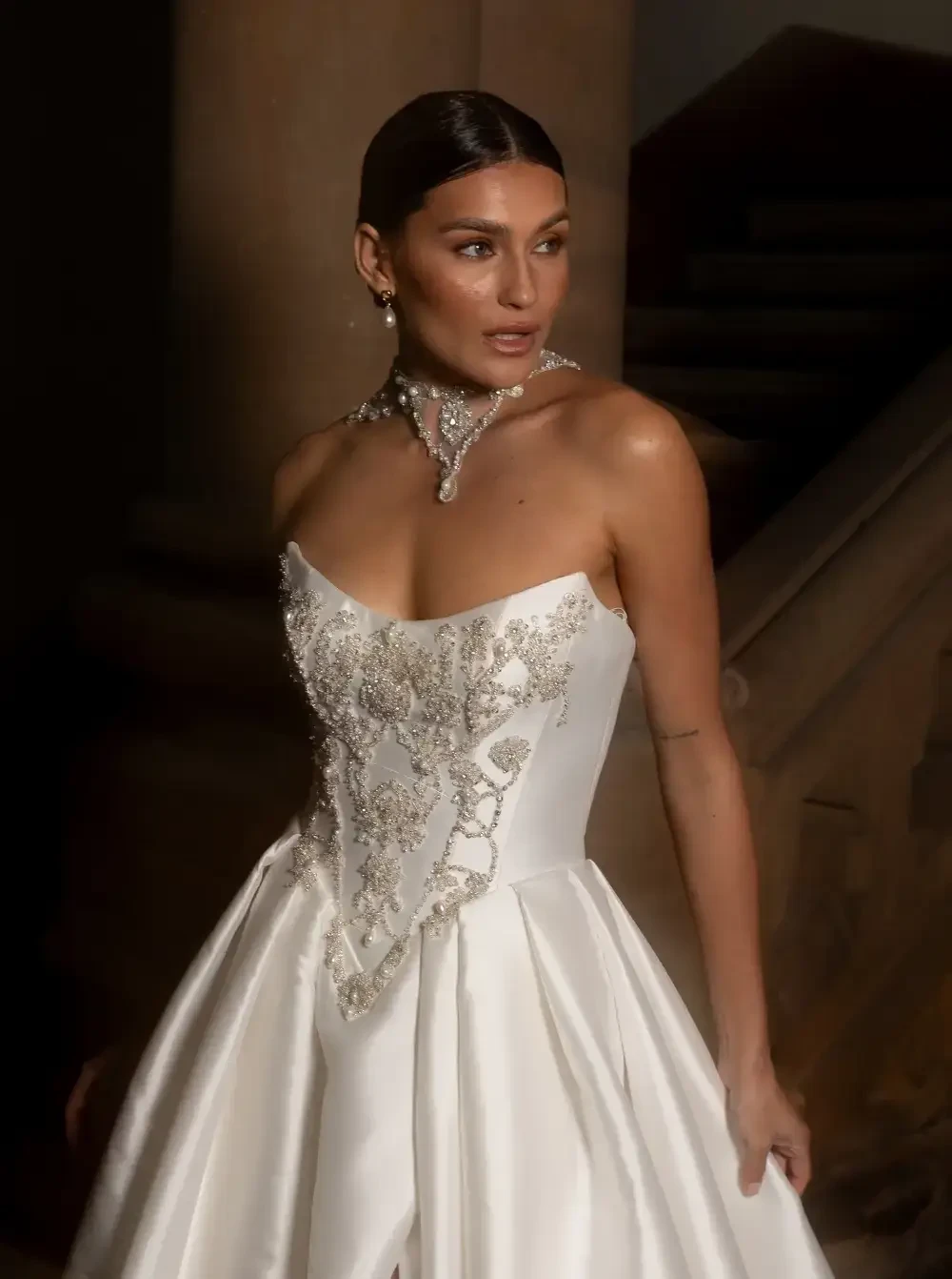 model is wearing an elaborate strapless ball gown